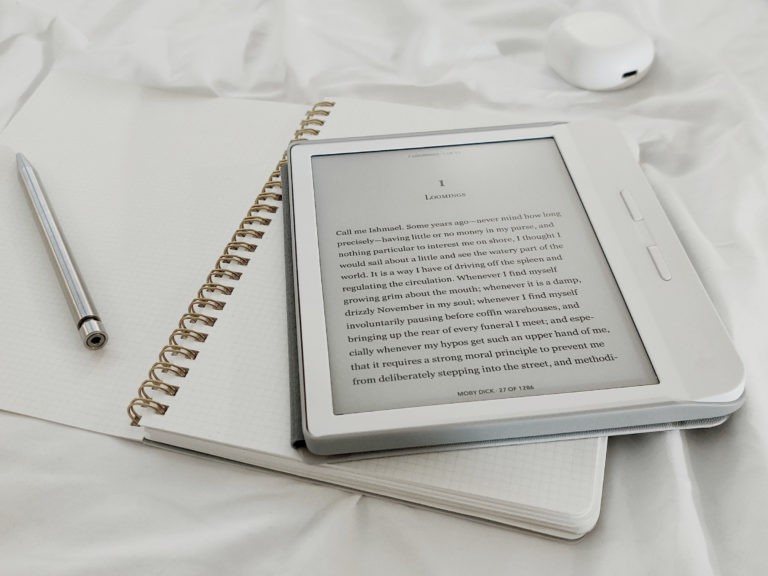 liseuse affichant un e-book, crayon et cahier