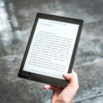 person holding black e book reader