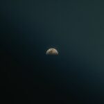 the moon is seen through a dark sky